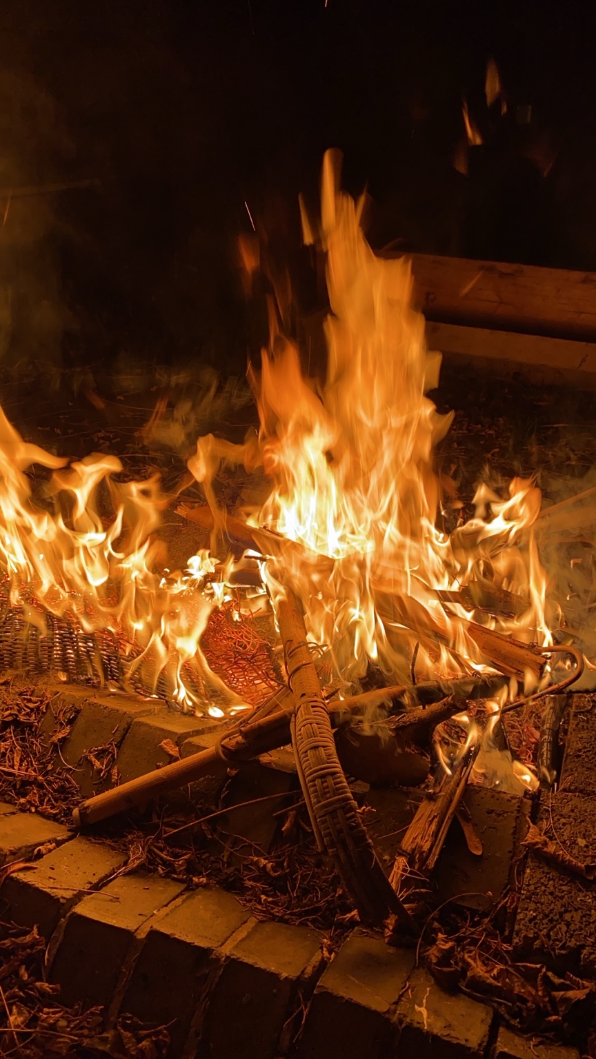 A bright fire with flames rising among logs.