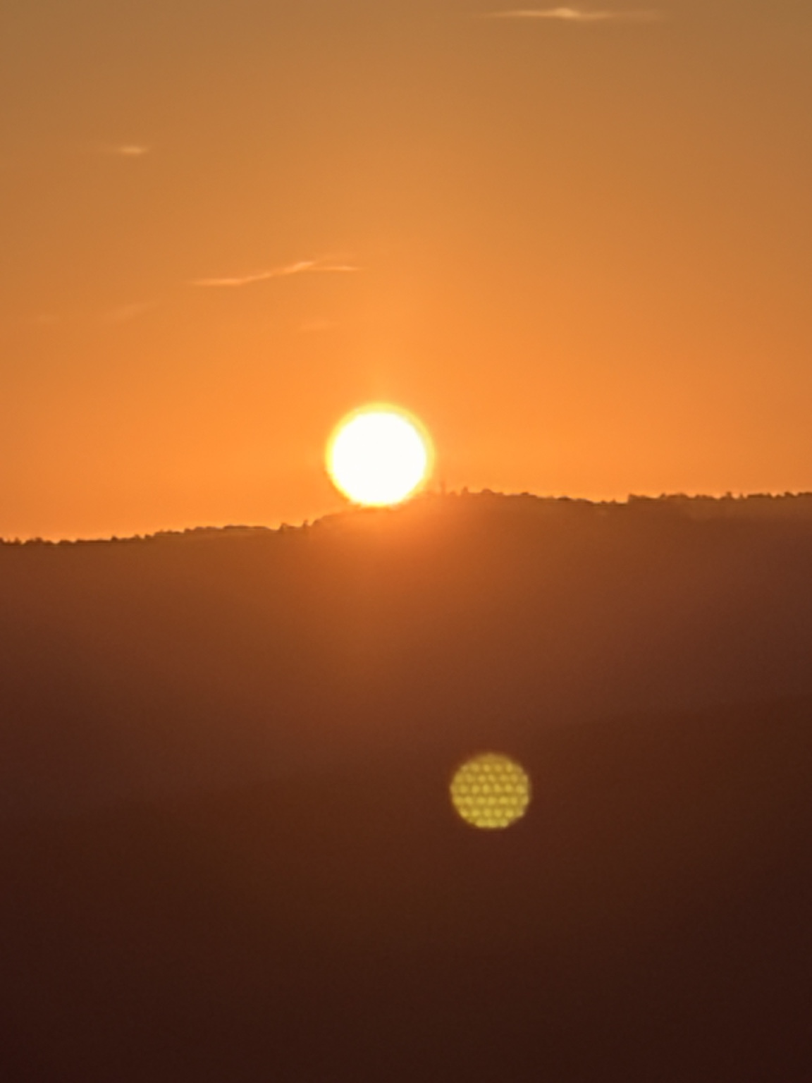 An orange sun above a dark horizon.